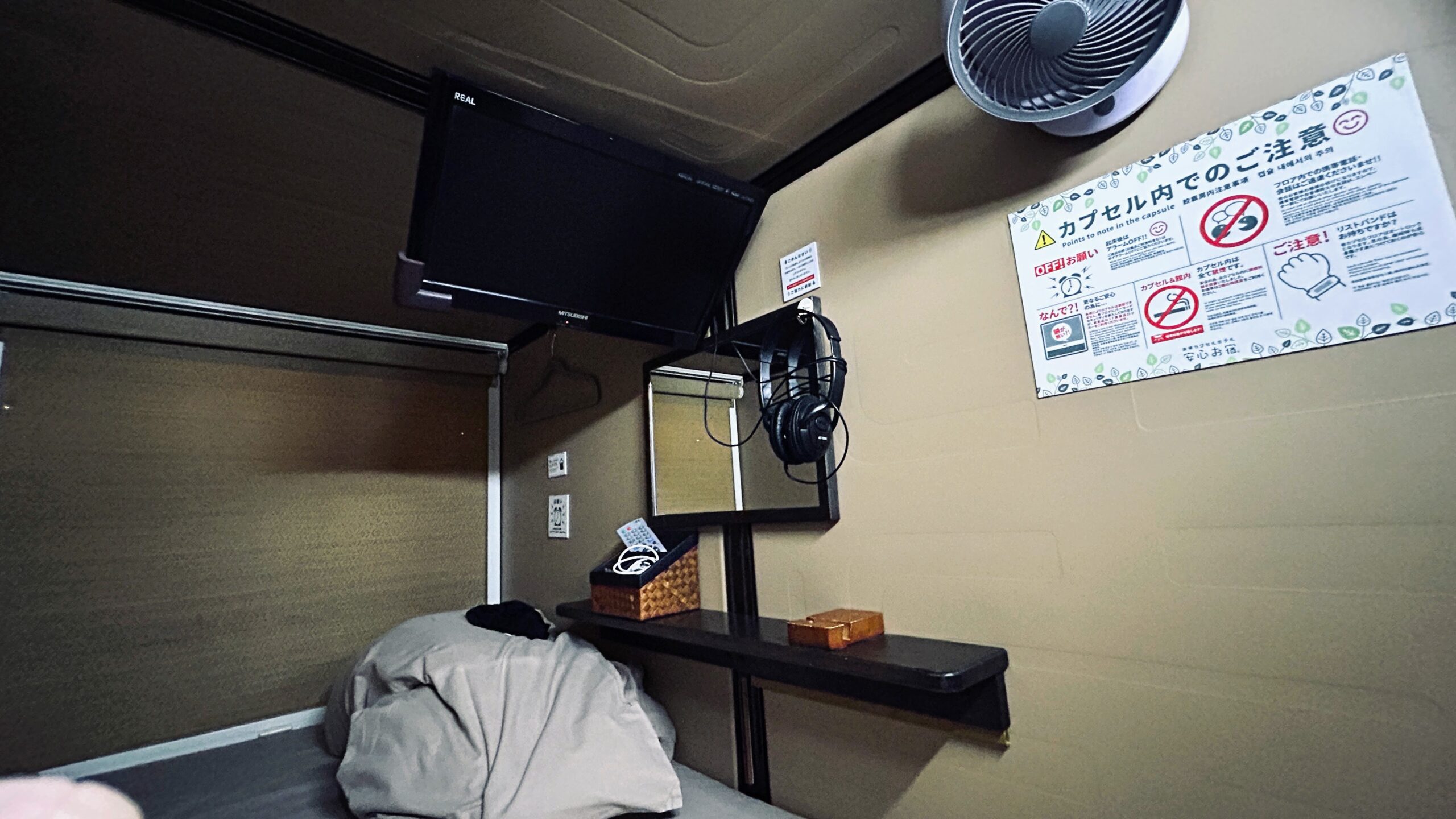 安心お宿 秋葉原 カプセル内全体（TV・ヘッドホン・棚）